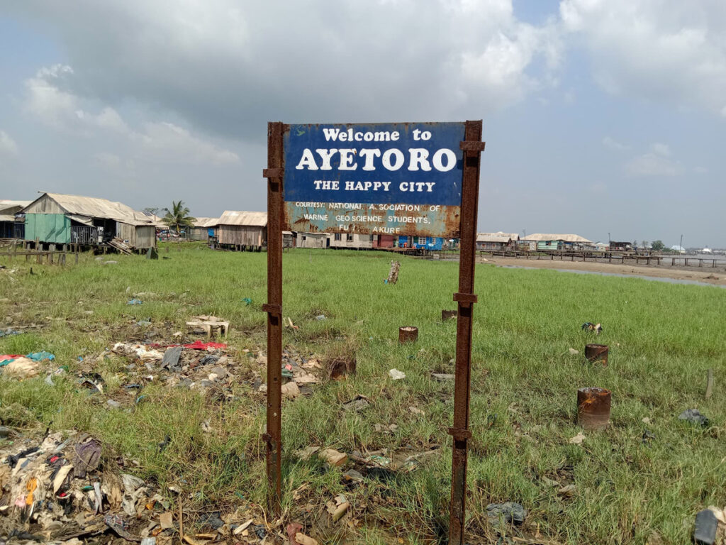 Das Ortschild von Ayetoro mit dem Beinamen "The Happy City"