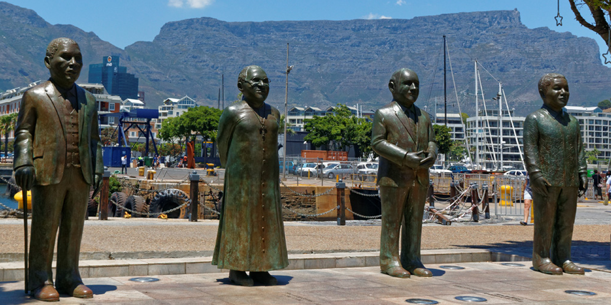 Statuen der vier südafrikanischen Friedensnobelpreisträger am Nobel Square in Kapstadt. Von links nach rechts: Albert Luthuli (Friedensnobelpreis 1960), Desmond Tutu (1984), Frederik Willem de Klerk und Nelson Mandela (beide 1994). Foto: Erik Koole Photography / Shutterstock.com