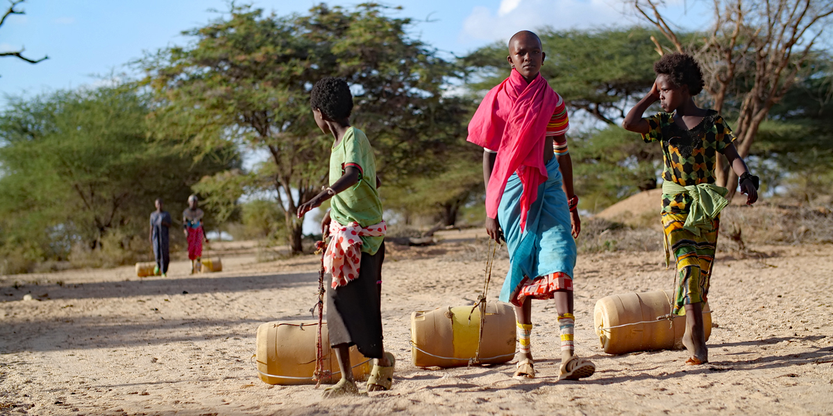 Kinder in Kenia ziehen Wasserfässer hinter sich her - Bild: Charles Kariuki / IPS