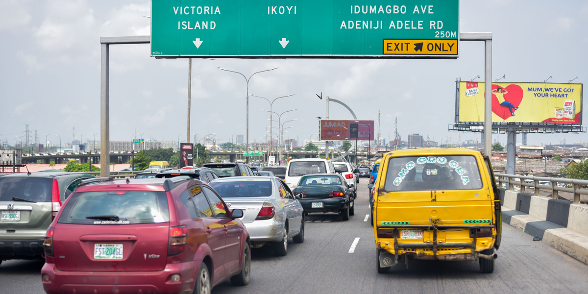 Straßenverkehr in Lagos, Nigeria, mit Wegweisern nach Victoria Island und Ikoyi